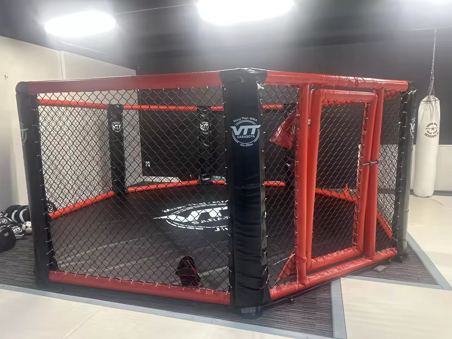 Custom MMA octagon installed at VTT Sarasota gym with branded padding and mat graphics